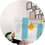 a person reading a megazine from indow window